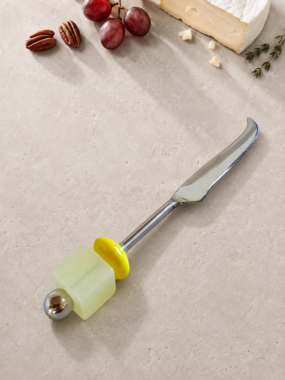 Cheese knife with a pale green and yellow beaded handle