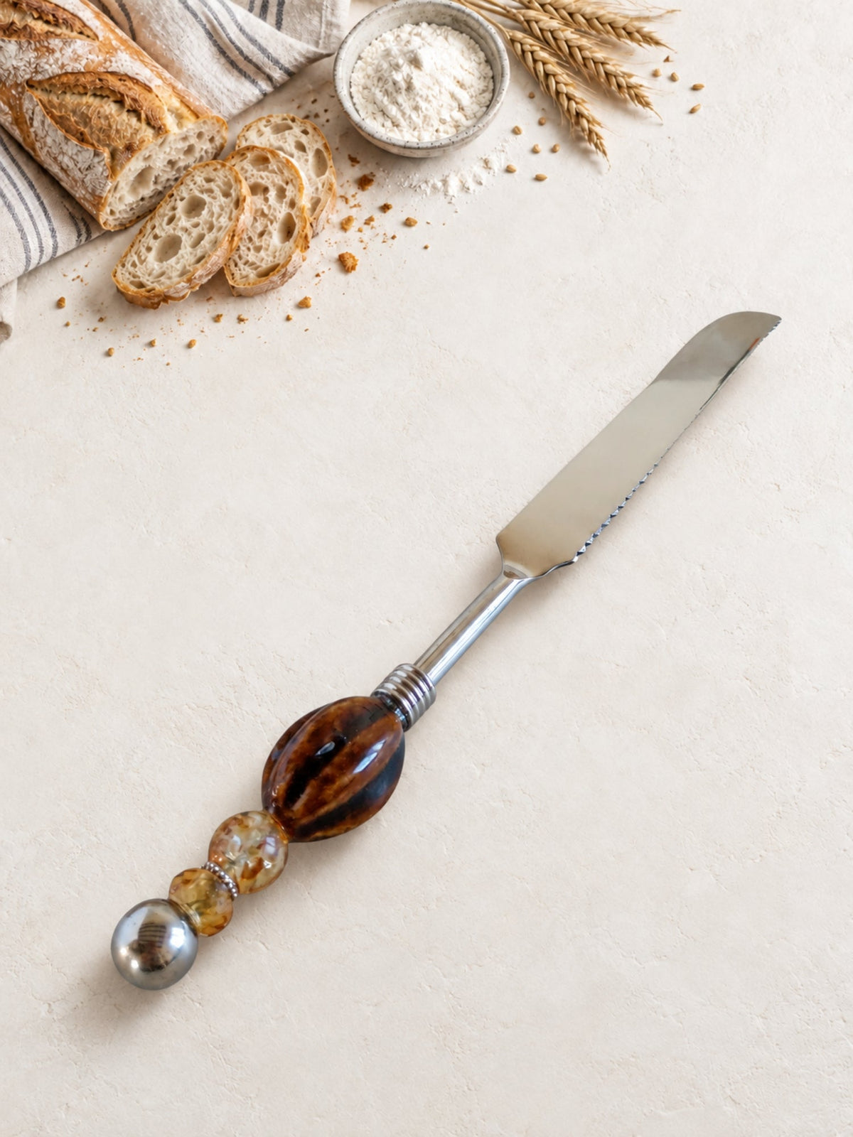 Bread knife with a brown, black and amber-coloured beaded handle
