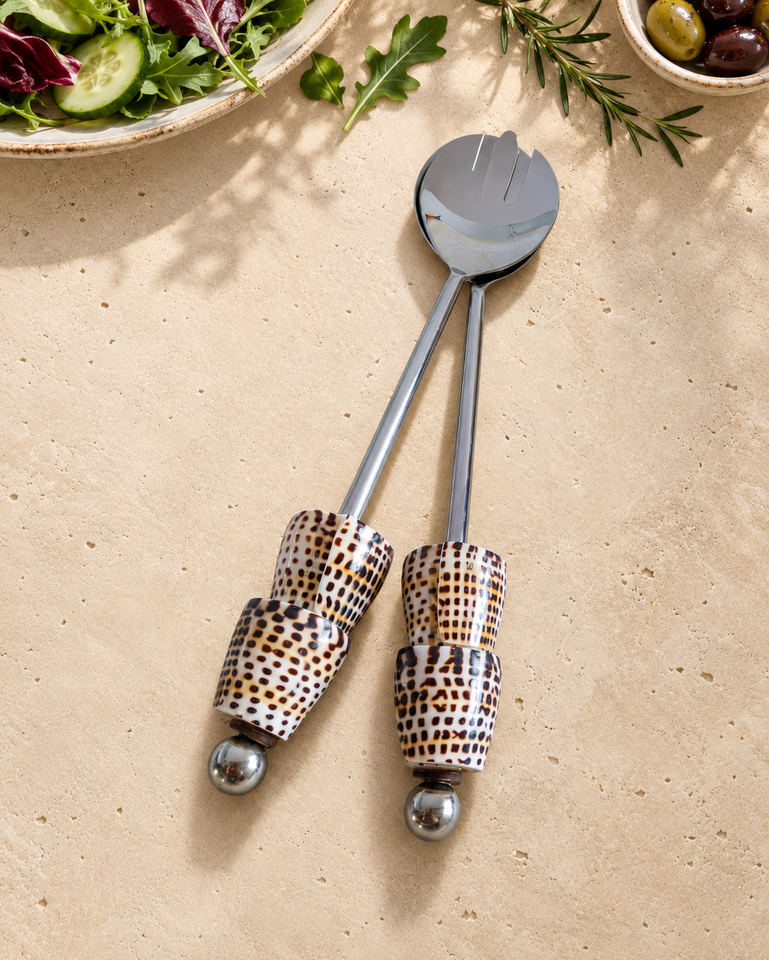 Silver-coloured salad serving set featuring patterned shell handles in cream, brown and black, with polished silver end beads, designed as The Esti.