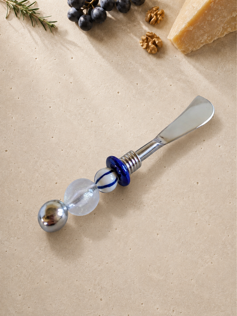 The Aida decorative butter knife with a silver blade, translucent bead, blue glass accents and a polished silver end bead.