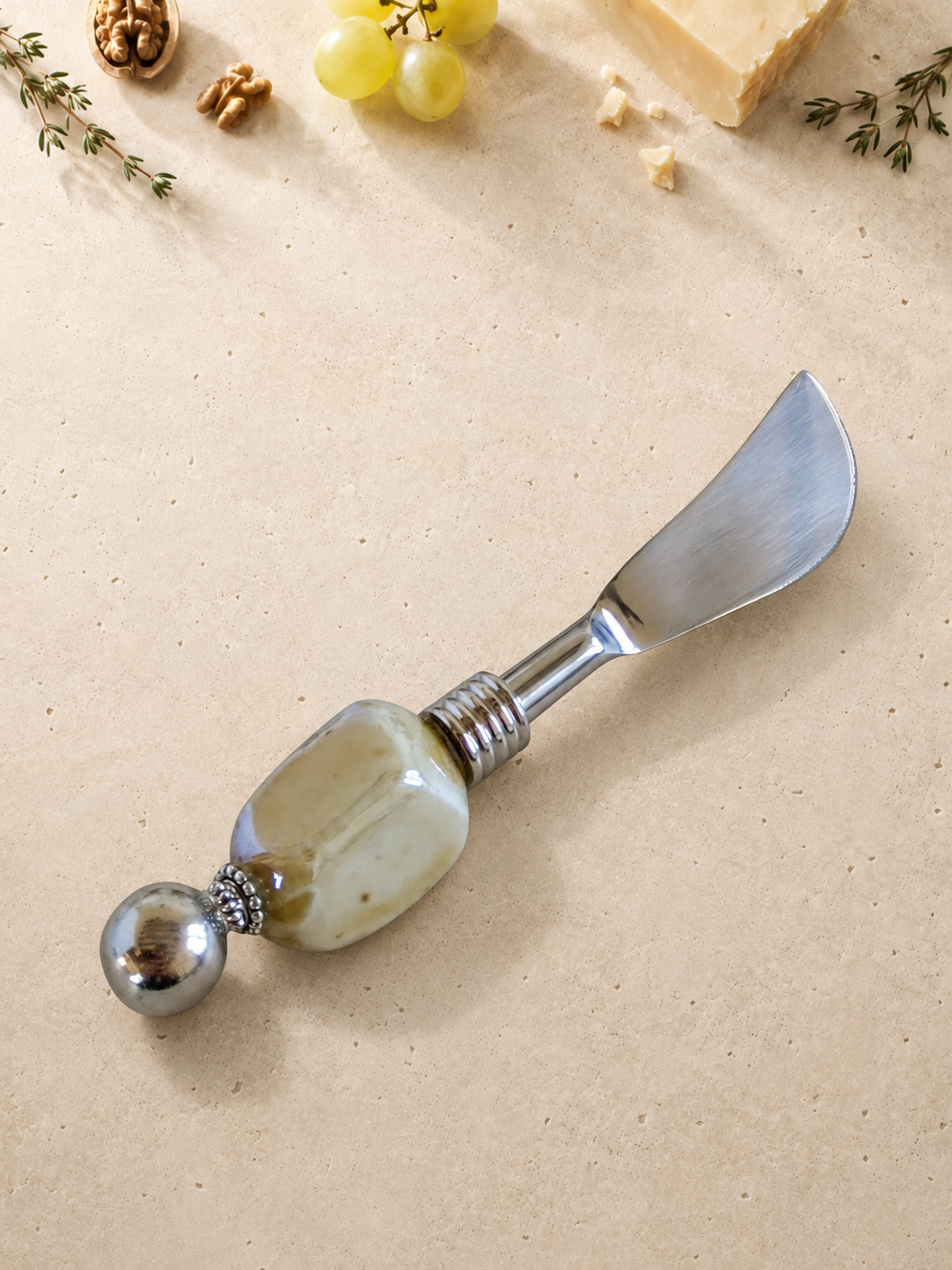 The Chadeer butter knife featuring a silver blade, a large cream-coloured marbled bead and a polished silver end bead.