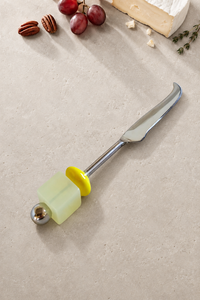 The Emrah cheese knife featuring a silver-coloured curved blade, a translucent pale yellow bead, a bright yellow disc bead and a polished silver end bead.