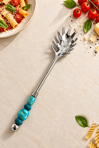 Decorative pasta spoon with turquoise beads, silver-coloured metal detailing and a handcrafted handle, The Hyda.