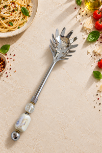 Silver-coloured pasta spoon with a handcrafted beaded handle in pearl-look tones and decorative accents, designed as The Moiz.