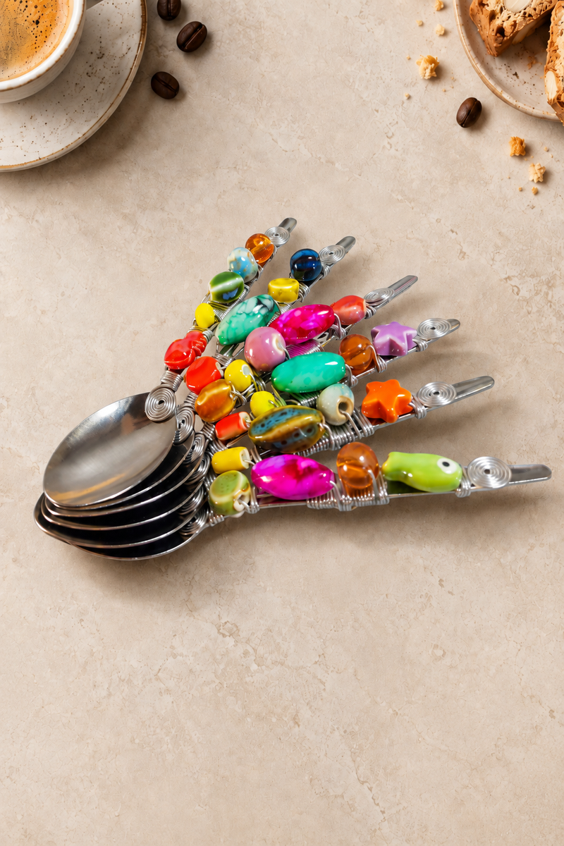 The Nairi set of 6 decorative coffee spoons with silver-coloured spoon heads, colourful glass and ceramic beads in pink, turquoise, yellow, orange and green, finished with silver wire detailing.