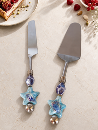 The Romil cake serving set featuring a silver-coloured cake knife and cake server with blue and purple glass beads, turquoise starfish details and polished silver end beads.