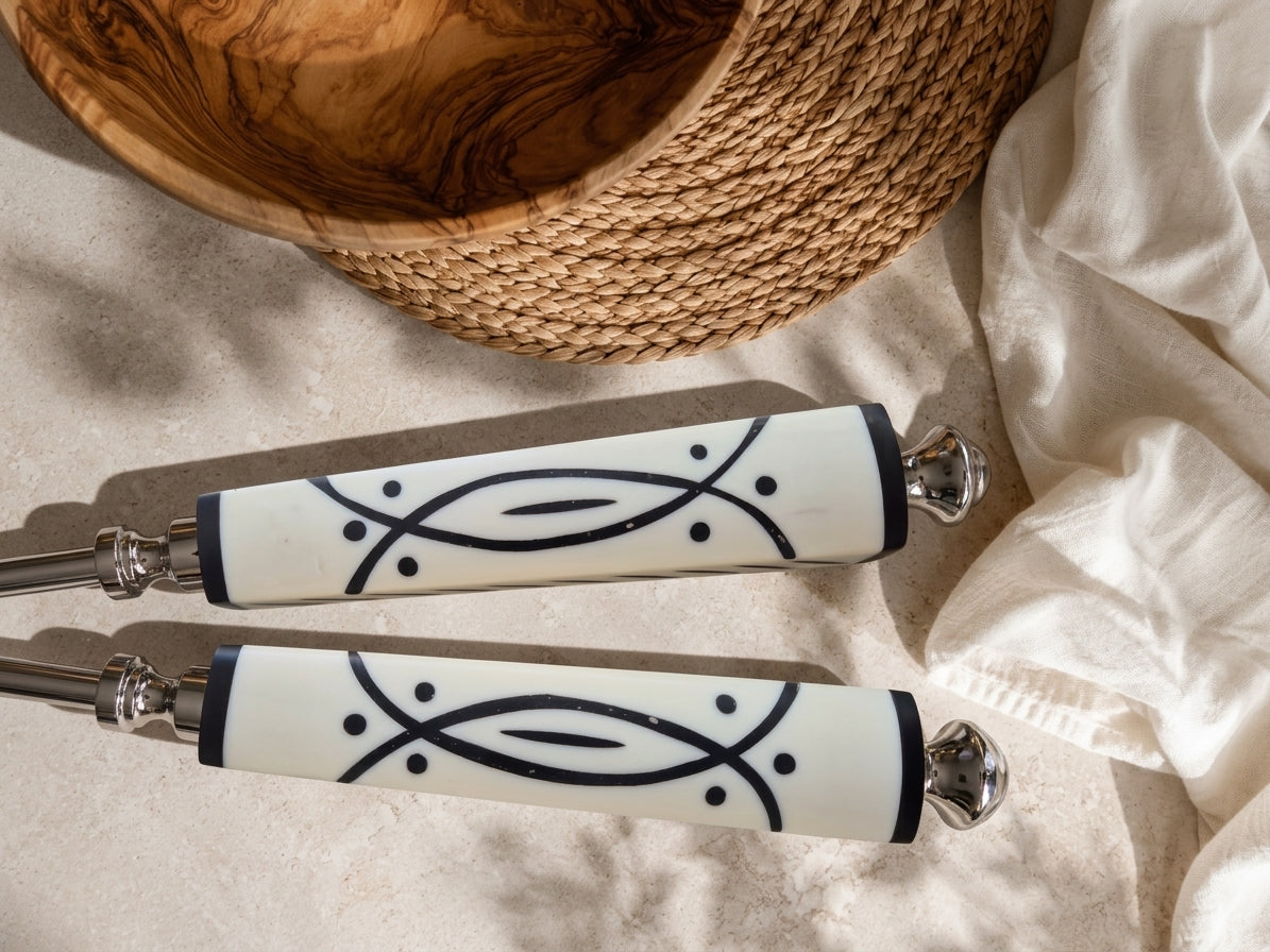 The Avani salad serving set with silver heads and white and black graphic handles