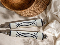 The Avani salad serving set with silver heads and white and black graphic handles