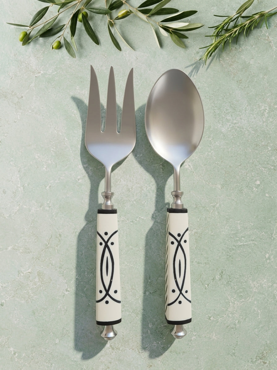 The Avani Salad Servers by Zapurah with white and black resin handles and silver finish