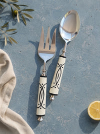 Salad serving spoon and fork with silver heads and white and black patterned handles, The Avani