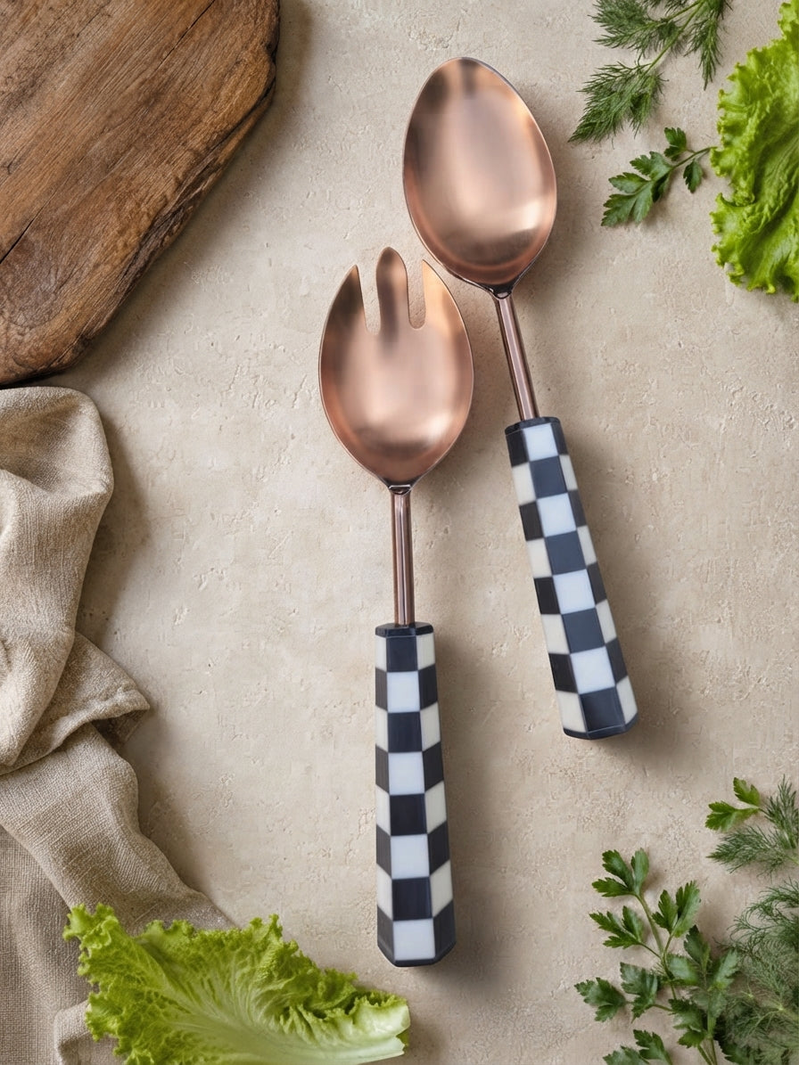The Azara salad serving spoon and fork with rose gold heads and black and white checkered handles