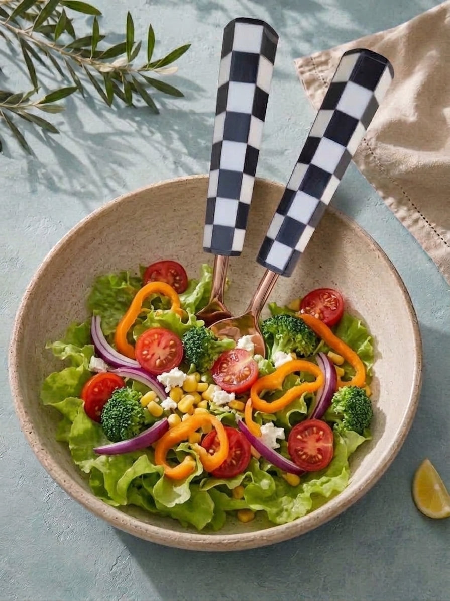 The Azara salad serving set with black and white checkerboard handles and rose gold heads