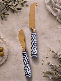 The Elara Cheese Knife Set by Zapurah with white and black resin handles and gold finish