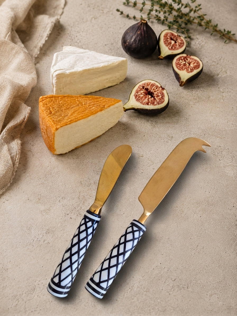 The Elara cheese knife set with gold metalwork and black and white lattice patterned handles
