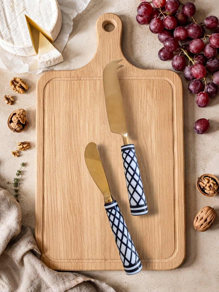 Gold cheese knives with black and white patterned handles, the Elara cheese knife set