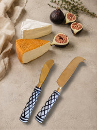 The Elara cheese knife set with gold heads and black and white patterned handles