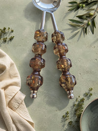 Detail of the smoky brown beaded handles with golden flecks on The Kalina salad serving set