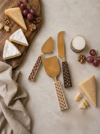 The Kartika cheese knife set with gold heads and mixed brown, ivory and dark brown patterned handles