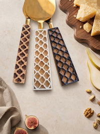 Close up of The Kartika cheese knives with gold heads and mixed brown, ivory and dark brown handles