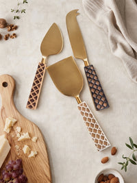 The Kartika cheese knives with gold heads and animal inspired patterned handles in brown, ivory and dark brown
