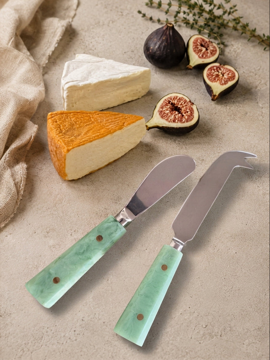 Two cheese knives with silver heads and jade green resin handles, The Maraya
