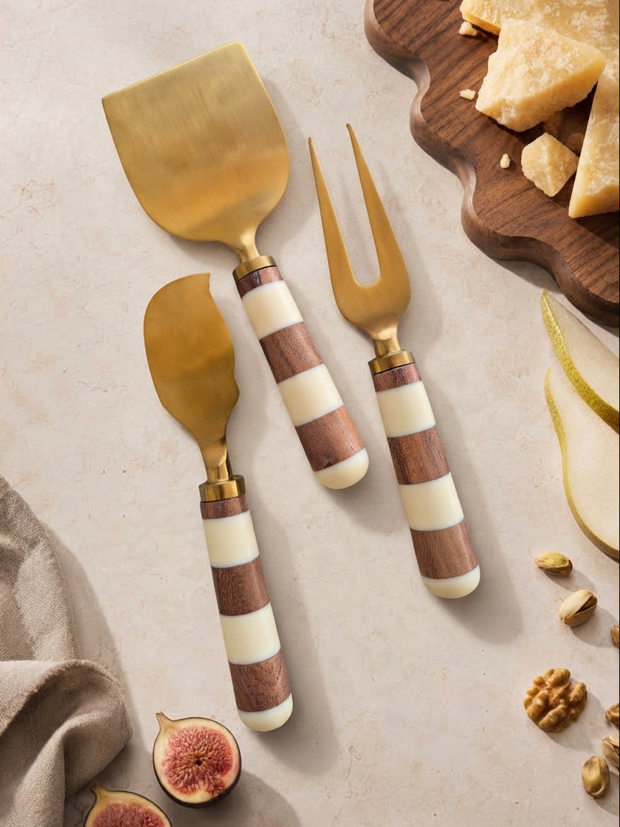 Three cheese knives with gold heads and brown and ivory striped handles, The Nalaya