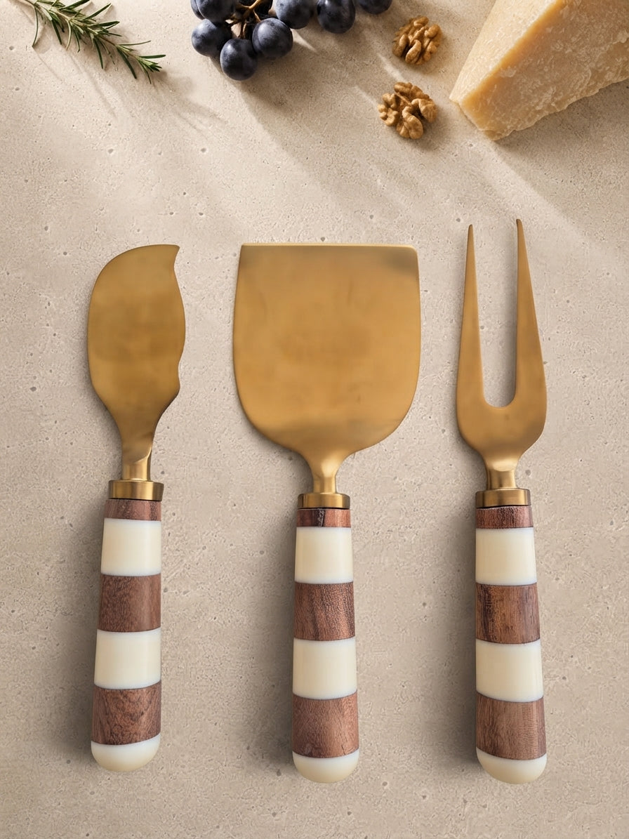 The Nalaya cheese knife set with gold heads and brown and ivory striped handles