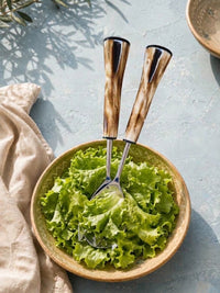 The Nalira salad serving set with silver finish and marbled brown and cream handles