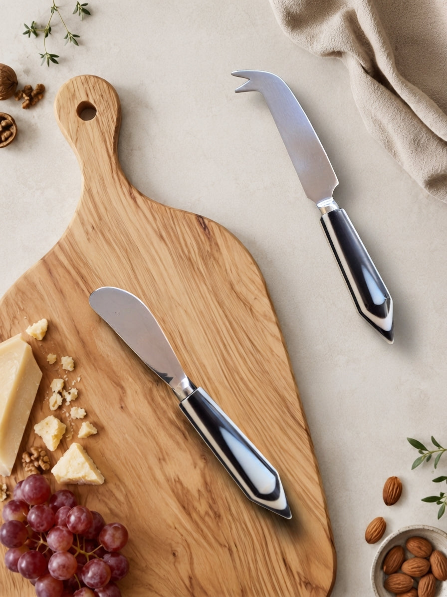 The Rona cheese knife set with silver heads and black and white resin handles