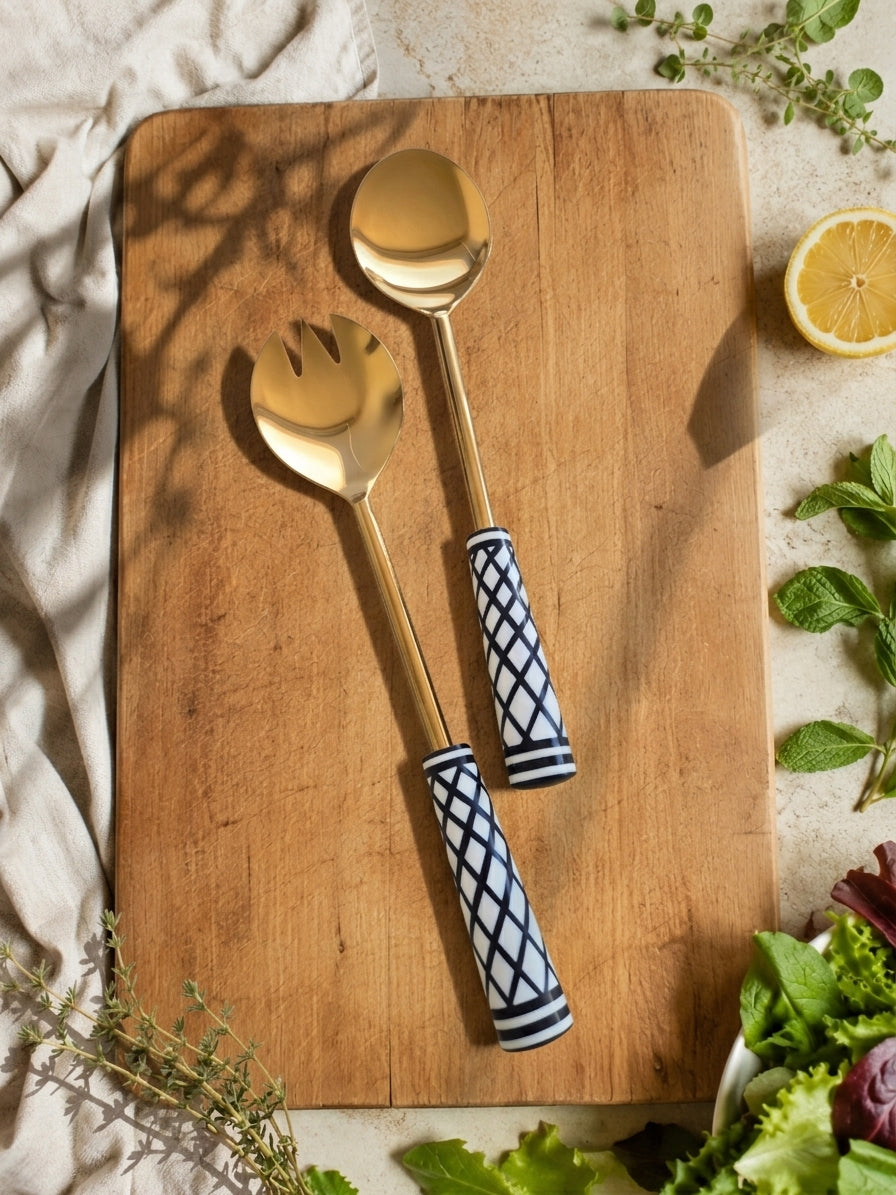 The Savira salad serving set with gold finish and black and white geometric handles