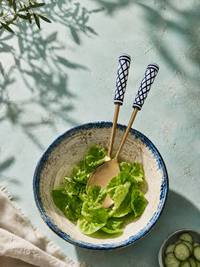 The Savira salad spoon and fork with gold metalwork and black and white lattice patterned handles