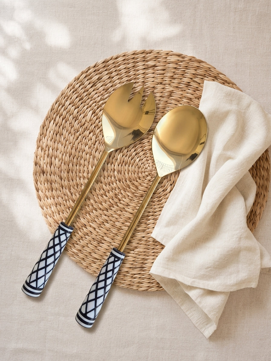 The Savira salad serving set with gold finish and black and white graphic handles