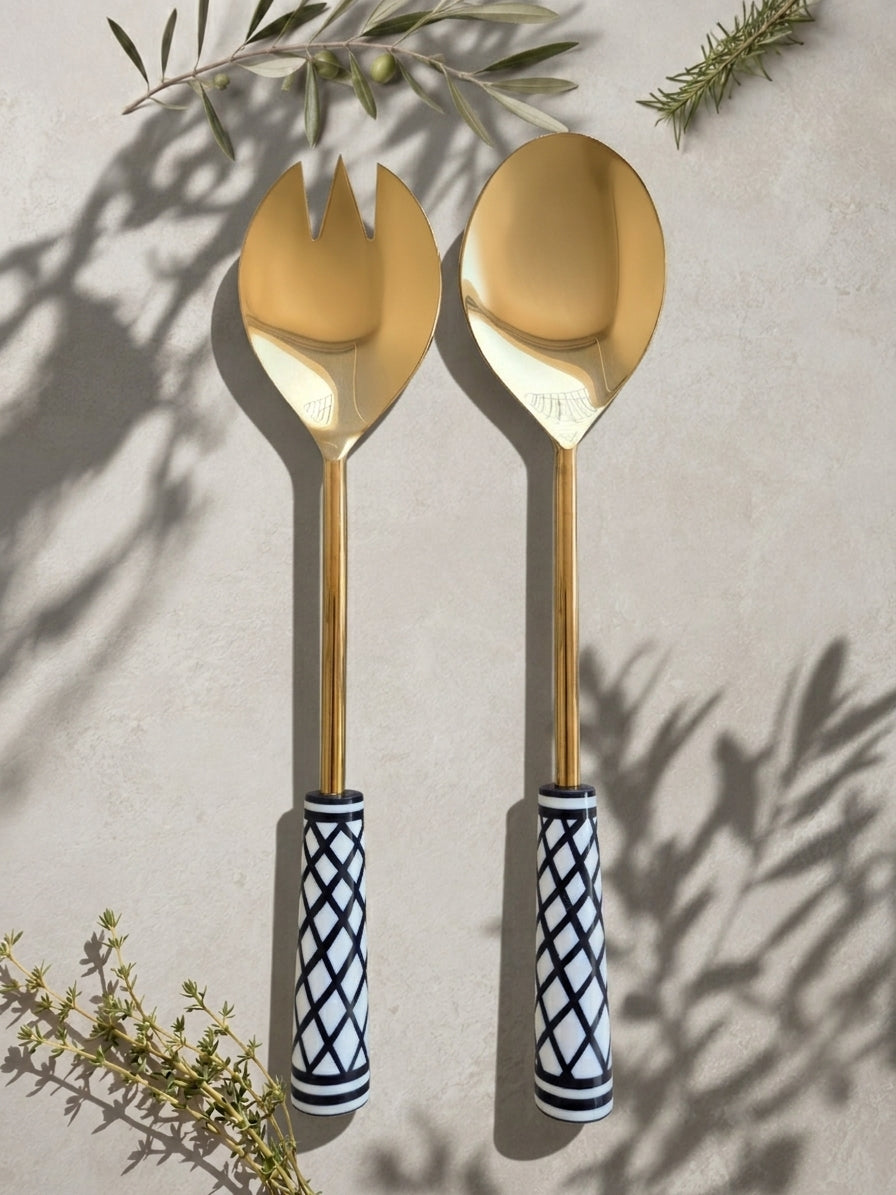 The Savira salad serving spoon and fork with gold heads and black and white patterned handles