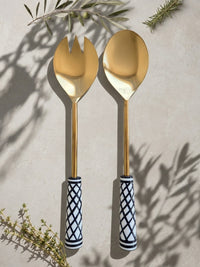 The Savira salad serving spoon and fork with gold heads and black and white patterned handles