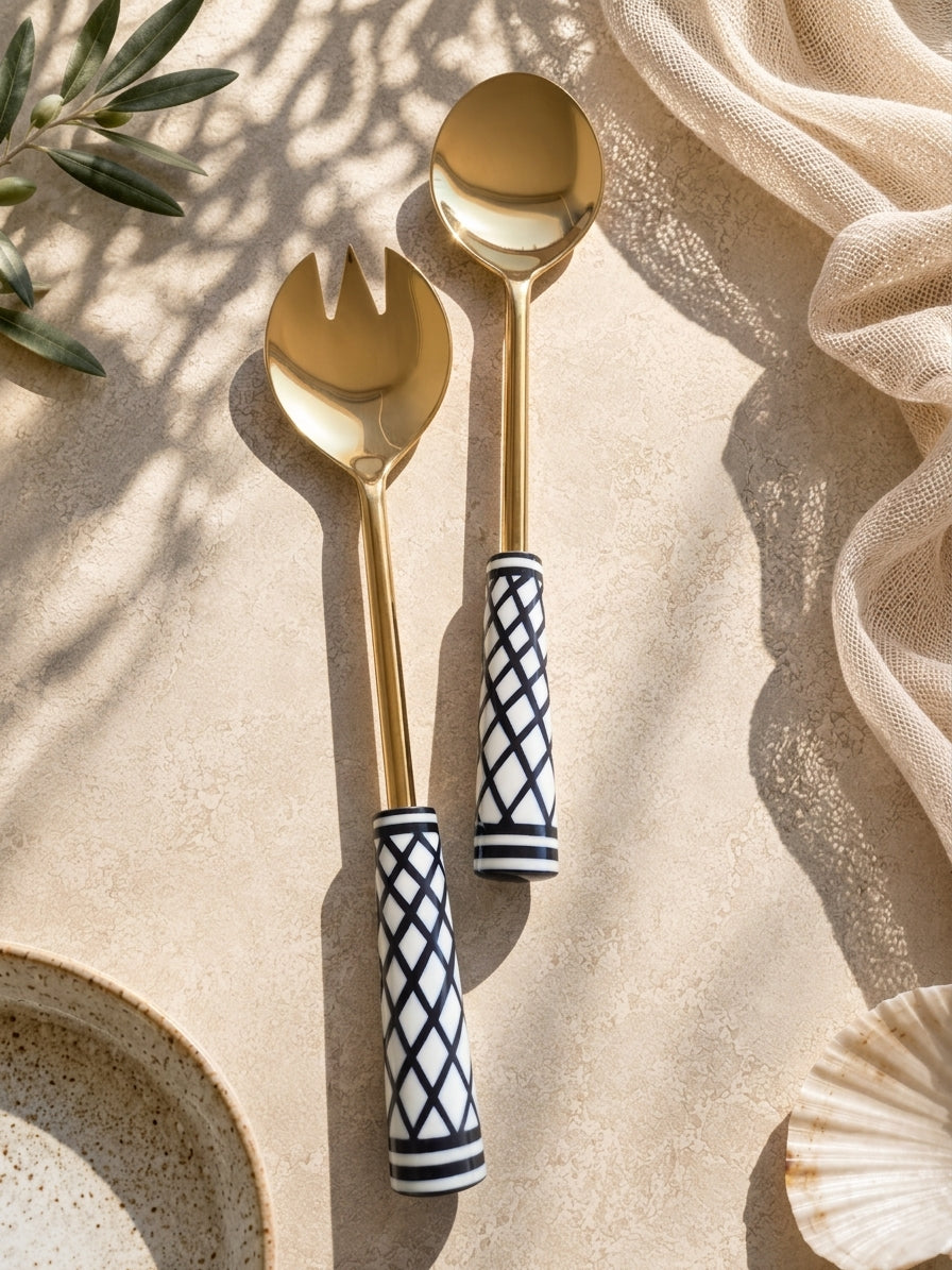 The Savira salad spoon and fork with gold metalwork and black and white geometric handles