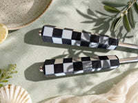Close up of The Talisa salad servers with silver heads and black and white geometric resin handles