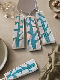 Three cheese knives with silver heads and turquoise, white and beige mosaic handles, The Teratai